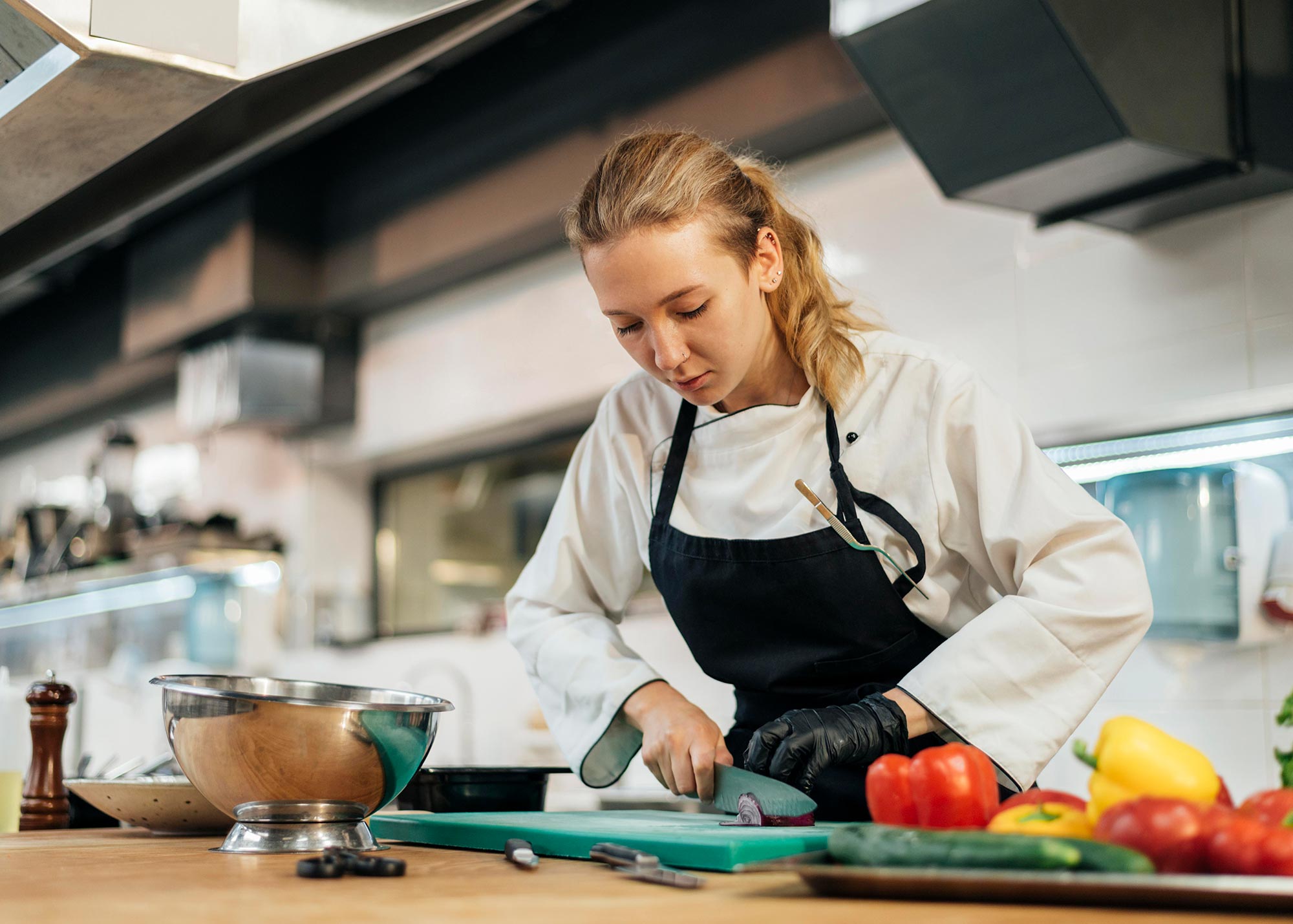 female chef chopping vegetables kitchen