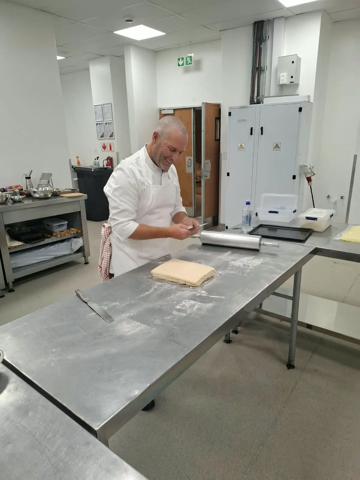Chef smiling beside a block of laminated pastry dough