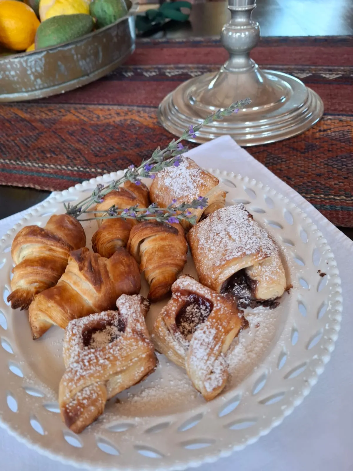 Overhead view of croissants and jam Danish pastries on a plate with lavender.
