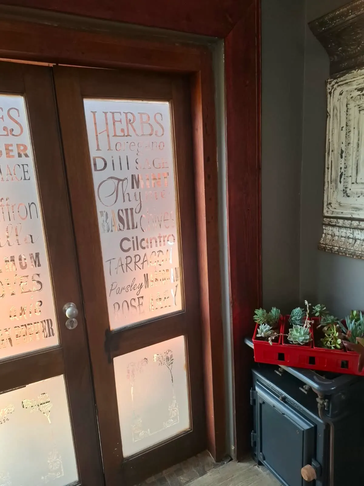 Frosted glass doors etched with herb names: oregano, dill, sage, thyme and basil