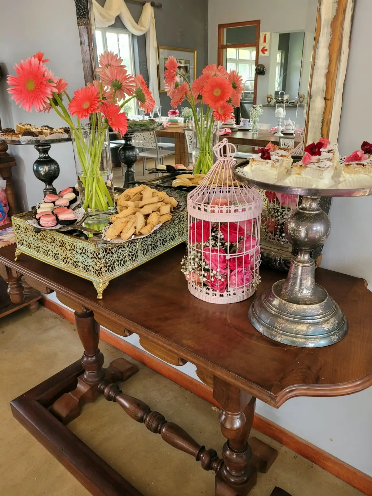 Dessert table with macarons, biscotti, custard slices and pink gerberas